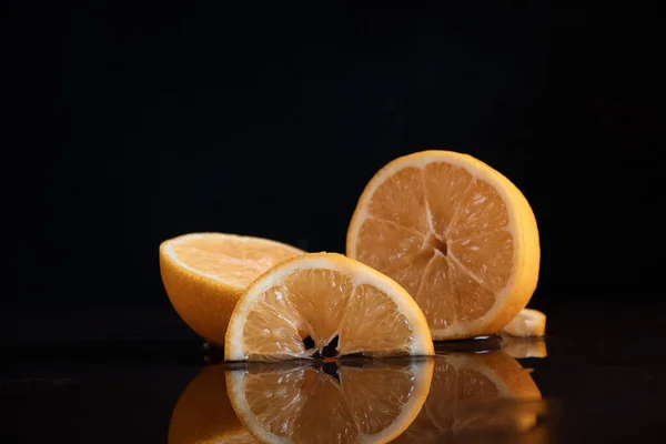 Masanın üzerinde limon limon dilimleri sulu kesilmiş arka planda su suyundaki yansıma bulanık.