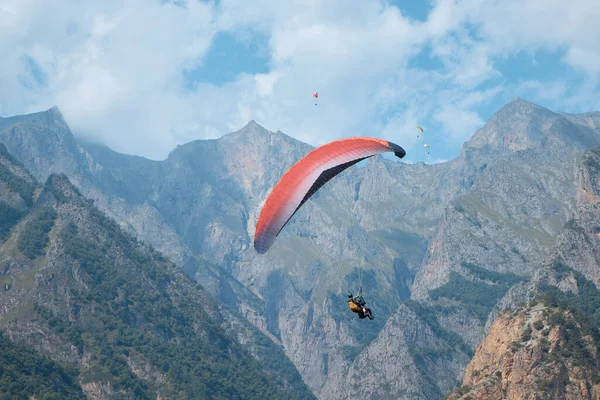 Havada paraşüt, spor, arka planda paraşüt dağlarda, kayalarda, sislerde, bulutlarda