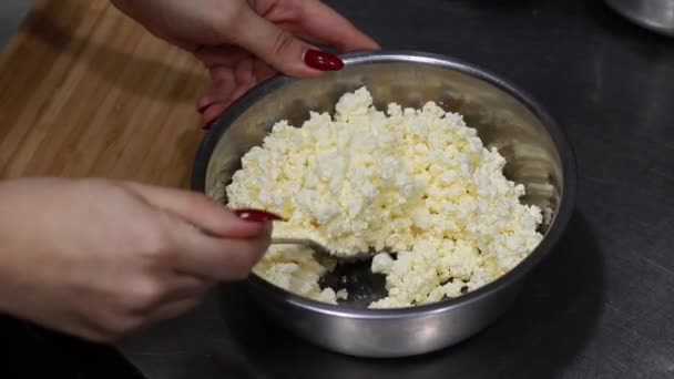Remuer à la main le fromage cottage dans un bol avec une cuillère, masse de caillé dans une casserole vue sur le dessus — Video