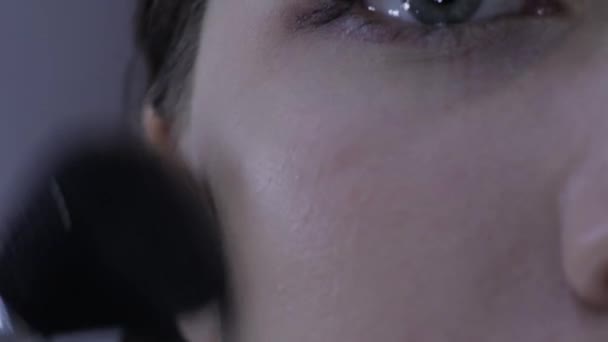 Close-up van een meisjes gezicht, het aanbrengen van poeder make-up, Europees uiterlijk, front view — Stockvideo