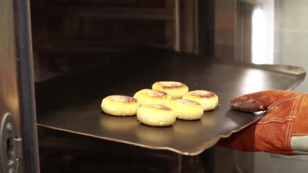 Kucharz wkłada do piekarnika arkusz z ciastem, duży piec — Wideo stockowe