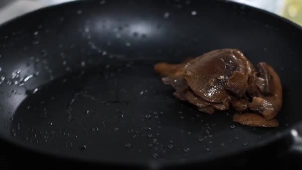 Гриби смажать на сковороді, кухар змішує їжу на сковороді з шпателем — стокове відео
