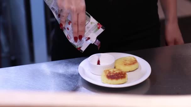 El cocinero vierte mermelada en tartas de queso, cocina en la cocina, postre cocido — Vídeos de Stock