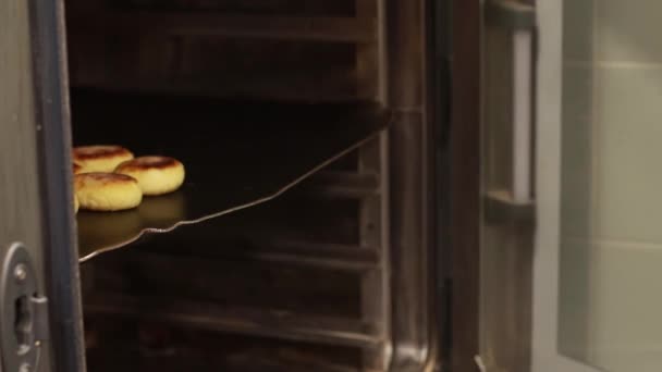 Kucharz wyciąga tacę do pieczenia z piekarnika, duży piekarnik — Wideo stockowe