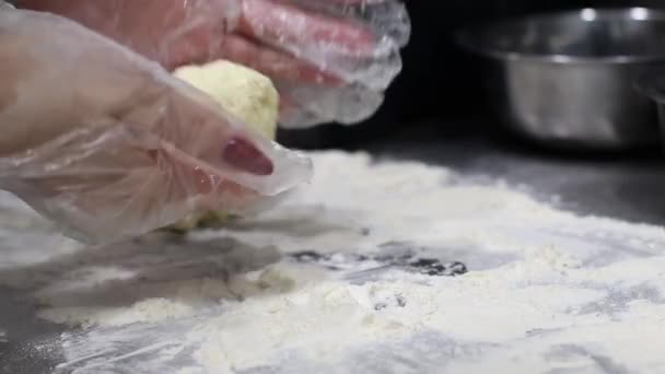 Le cuisinier fait des boules de pâte et les met prêt sur la table couverte de farine, faire un dessert dans la cuisine — Video