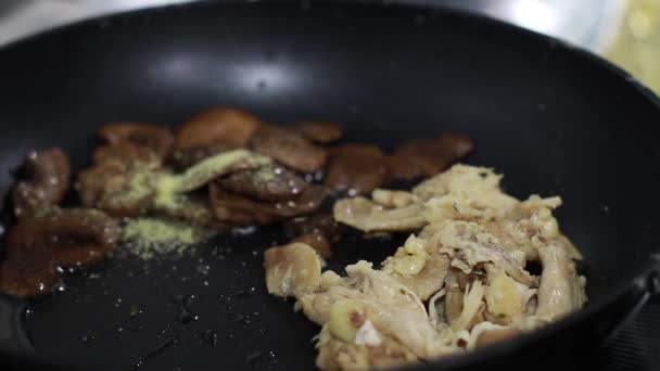 A gombát serpenyőben sütik, a szakács serpenyőbe keveri az ételt egy spatulával. — Stock videók