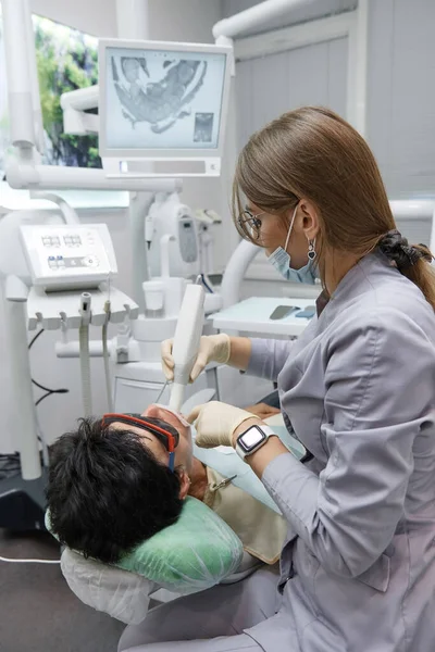 Dişçi, doktor hastaların dişlerini ve ağız boşluğunu üç boyutlu tarıyor.