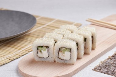 Bir porsiyon ekmek, Japon yemeği, masada suşi, Çin yemek çubukları, hafif arka plan.