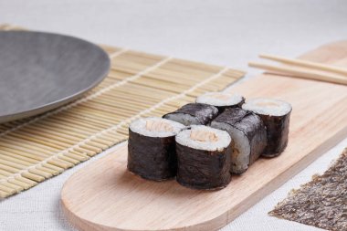 Bir porsiyon ekmek, Japon yemeği, masada suşi, Çin yemek çubukları, hafif arka plan.