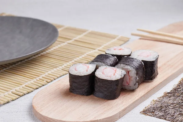 Bir porsiyon ekmek, Japon yemeği, masada suşi, Çin yemek çubukları, hafif arka plan.
