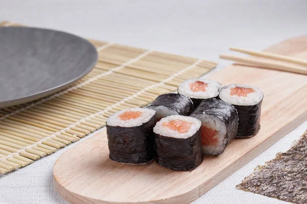 Bir porsiyon ekmek, Japon yemeği, masada suşi, Çin yemek çubukları, hafif arka plan.