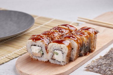 Bir porsiyon ekmek, Japon yemeği, masada suşi, Çin yemek çubukları, hafif arka plan.