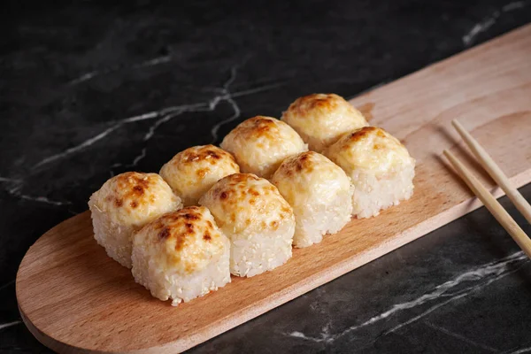 Bir porsiyon ekmek, Japon yemeği, masada suşi, Çin yemek çubukları, karanlık arka plan.