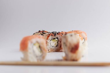 Odaklanan bir rulo, bulanık bir porsiyon, Asya yemeği, suşi ve balık yemeği.