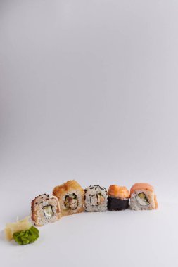 Masada birkaç farklı rulo var, Asya yemekleri, yan görüş, arka plan, suşi, zencefil ve wasabi.