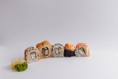 Masada birkaç farklı rulo var, Asya yemekleri, yan görüş, arka plan, suşi, zencefil ve wasabi.