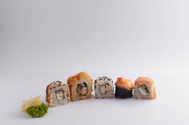 Masada birkaç farklı rulo var, Asya yemekleri, yan görüş, arka plan, suşi, zencefil ve wasabi.