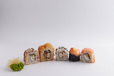 Masada birkaç farklı rulo var, Asya yemekleri, yan görüş, arka plan, suşi, zencefil ve wasabi.