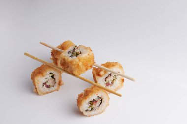 Masada birkaç rulo, Asya yemeği, Çin yemek çubuklarında denge, yan görüş, suşi.