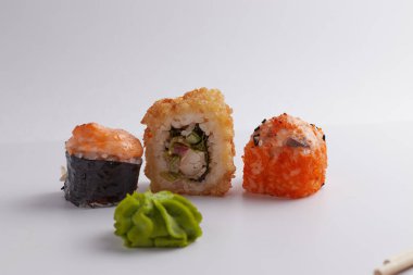 Masada birkaç farklı rulo var, Asya yemekleri, yan görüş, arka plan, suşi, zencefil ve wasabi.