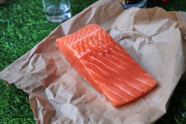 Masada kırmızı balık, bir dilim balık, deniz ürünleri ve alkol, yeşil çimen, tuzlanmış balık.