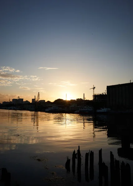 Zonsondergang op de rivier in de stad, zonnestralen, gouden uur, water en schepen, 's avonds landschap — Stockfoto