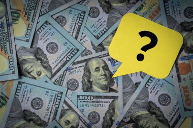 Konuşma balonunda soru işareti olan 100 dolarlık banknot yığını..