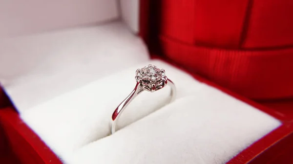 情人节珠宝 新年珠宝 用红色背景的钻石把漂亮的戒指围起来 背景模糊的当前框 订婚戒指 — 图库照片