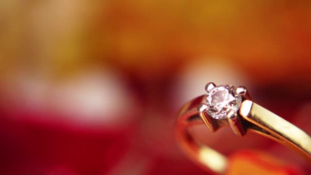 Ένα χρυσό δαχτυλίδι στο φόντο των εορταστικών γιρλάντες. Δώρο κοσμημάτων της Πρωτοχρονιάς. Κοσμήματα για τις 14 Φεβρουαρίου. Δαχτυλίδι εμπλοκής διαμαντιών — Αρχείο Βίντεο
