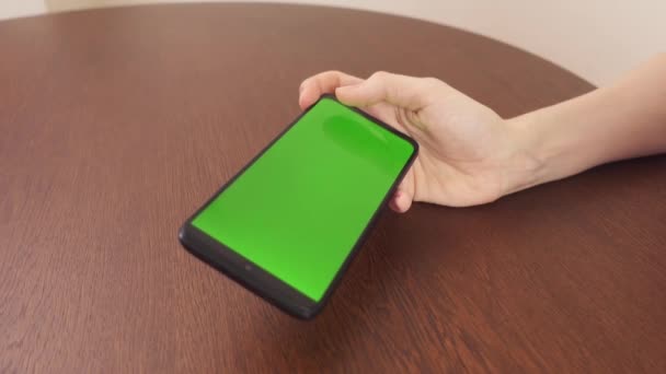 4k.Vista lateral. Mulher usando smartphone preto com tela verde.Mãos de pessoa rolando fotos, pressionando o dedo, lendo internet de mídia social, digitando texto ou compras on-line. Telefone celular em dois — Vídeo de Stock