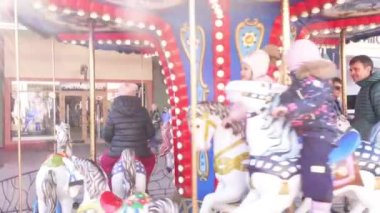 Rus Federasyonu. Moskova. Vnukovo outlet köyü. Vnukobo outlet köyündeki Atlıkarınca 2022. Atlıkarınca. Mutlu çocuklar ve güneş ışığıyla renkli bir atlıkarınca.