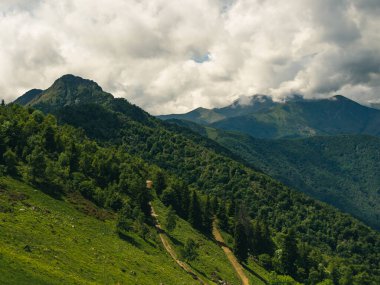 Dağların manzarası, güneşli bir günde panoramik manzara ve beyaz bulutlar.