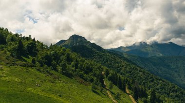 Dağların manzarası, güneşli bir günde panoramik manzara ve beyaz bulutlar.