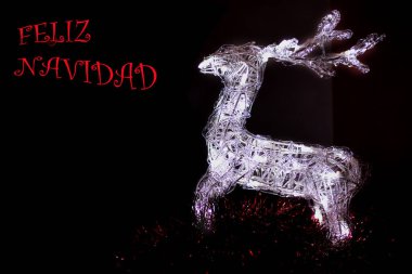 Noel süslemeleri; metin ve İspanyolca yazıtlar için siyah arkaplan ve boşluk üzerindeki yağmur geyikleri mutlu noeller