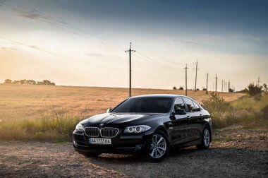 Kherson, Ukrayna - Haziran 2019. BMW 5 serisi F10 sahada siyah renkli. 