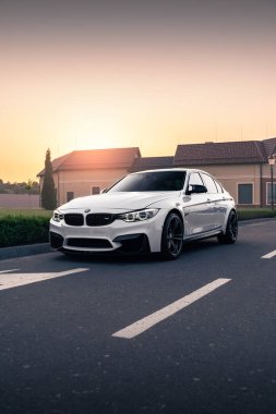 Güzel günbatımının arka planında beyaz BMW M3 F80. Kyiv, Ukrayna - Haziran 2021.
