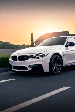 Güzel günbatımının arka planında beyaz BMW M3 F80. Kyiv, Ukrayna - Haziran 2021.