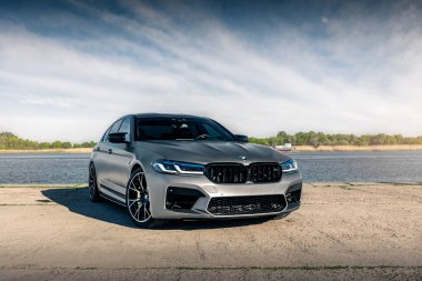 Nehrin arka planında yeni BMW M5 F90 yarışması. Kherson, Ukrayna - Mayıs 2021.