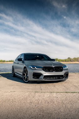 Nehrin arka planında yeni BMW M5 F90 yarışması. Kherson, Ukrayna - Mayıs 2021.