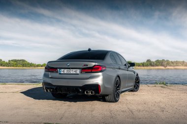 Nehrin arka planında yeni BMW M5 F90 yarışması. Kherson, Ukrayna - Mayıs 2021.