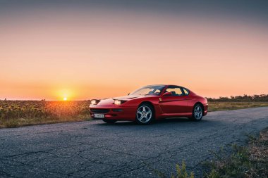 Klasik retro Ferrari 456GTA günbatımında kırmızıyla bitirdi. Kherson, Ukrayna - Ağustos 2021.