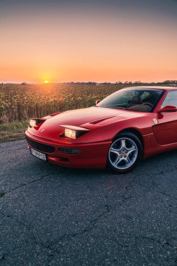 Klasik retro Ferrari 456GTA günbatımında kırmızıyla bitirdi. Kherson, Ukrayna - Ağustos 2021.