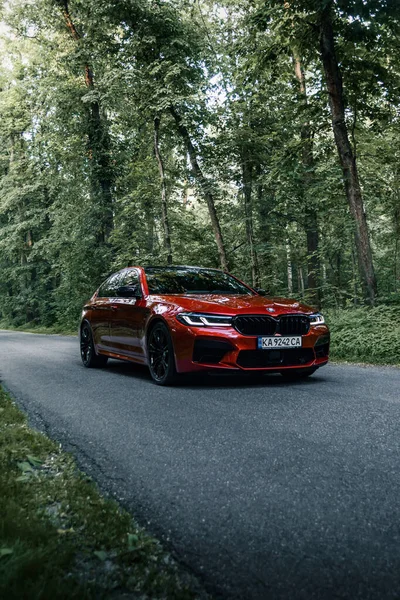 新しいBmw F90 Lci競争森の道路上の赤い色で ウクライナのキエフ 2021年6月 — ストック写真