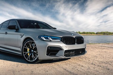 Nehrin arka planında yeni BMW M5 F90 yarışması. Kherson, Ukrayna - Mayıs 2021.