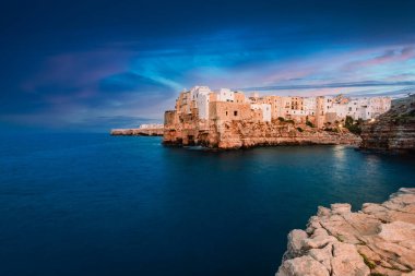 Polignano a Mare, İtalya - Ağustos 2021: Polignano a Mare, gün batımında (mavi saat) köyün önündeki panoramik noktadan görülüyor