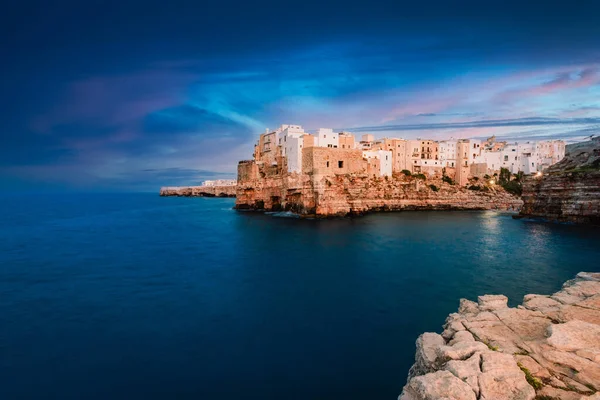 Polignano a Mare, İtalya - Ağustos 2021: Polignano a Mare, gün batımında (mavi saat) köyün önündeki panoramik noktadan görülüyor