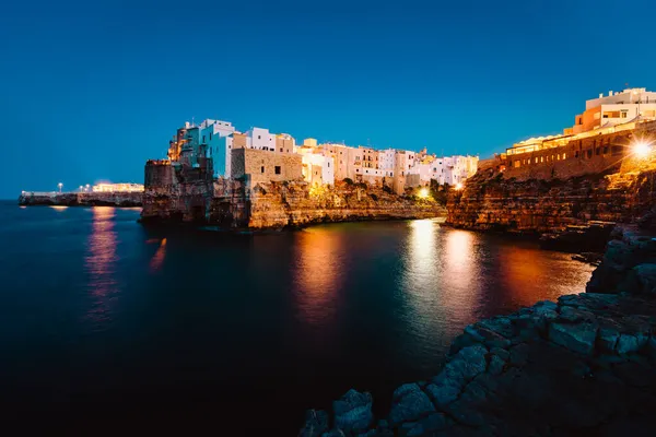 Polignano a Mare, İtalya - Ağustos 2021: Polignano köyünün gece manzarası ışıklarla aydınlatıldı