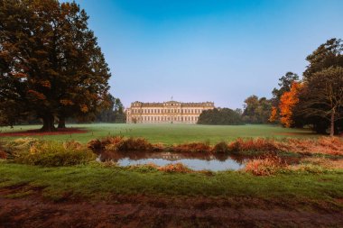 Monza, İtalya - Kasım 2021: The Royal Villa of Monza, neoklasik tarzda bir bina, ön planda küçük bir dere bulunan parkın yeşiliyle çevrili.