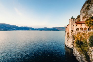Leggiuno, Varese, İtalya - Aralık 2021: Santa Caterina del Sasso Hermitage, Maggiore Gölü üzerinde gün batımında