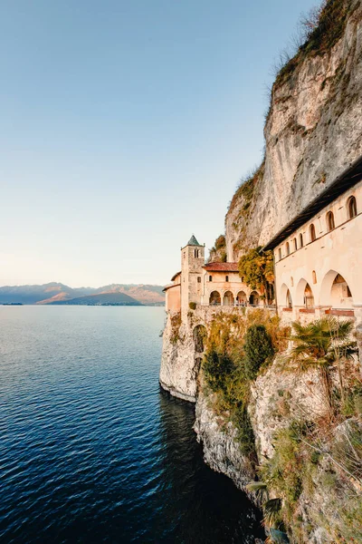 Leggiuno, Varese, İtalya - Aralık 2021: Santa Caterina del Sasso Hermitage, Maggiore Gölü üzerinde gün batımında